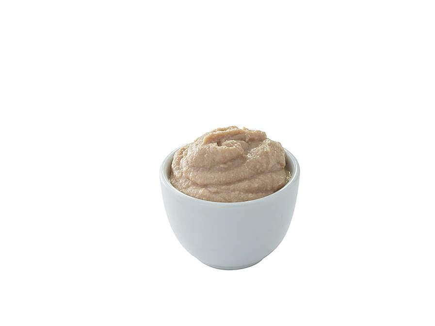 Small white bowl filled with a beige substance on a white background.