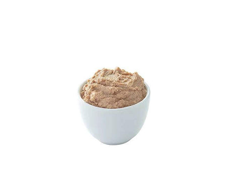 White bowl filled with a brown spreadable food on a white background.