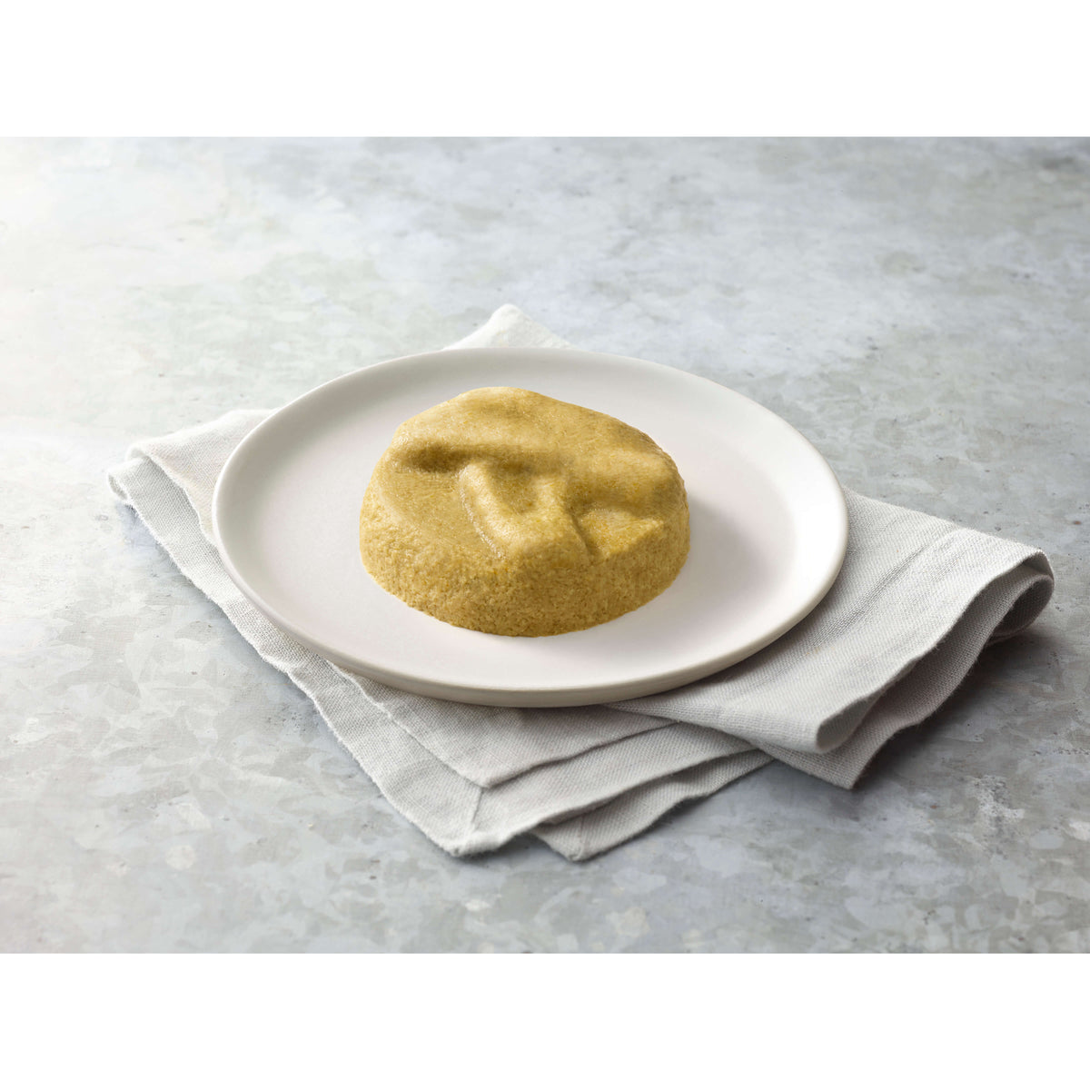 Broccoli on a white plate with a gray napkin on a light gray surface.