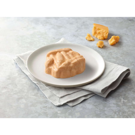 Mac and cheese on a white plate with a napkin on a gray surface.
