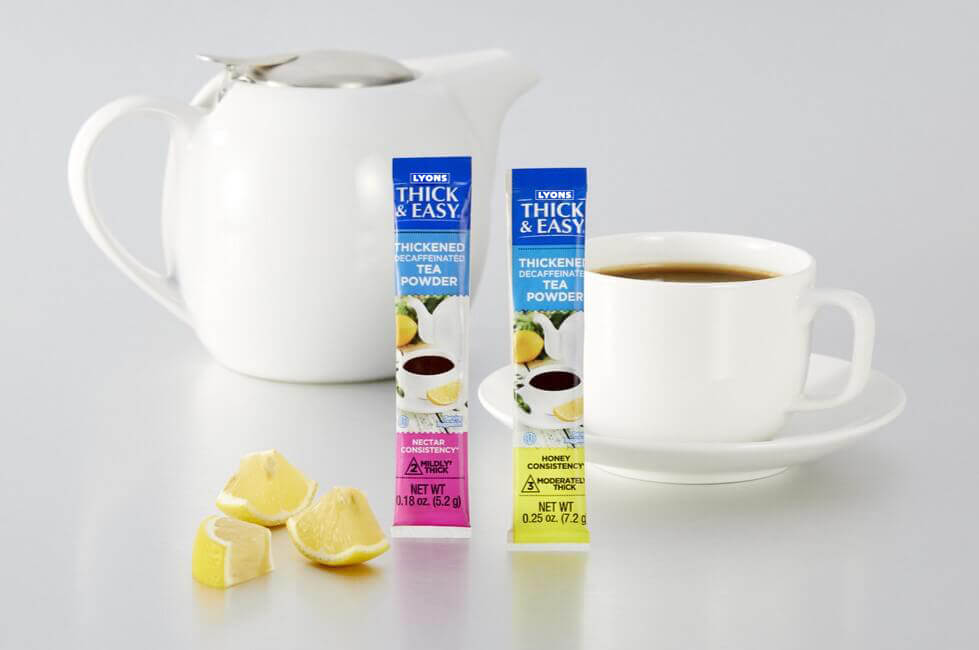 Two boxes of thick and easy thickening tea powder with a cup of tea and lemons on a white background.