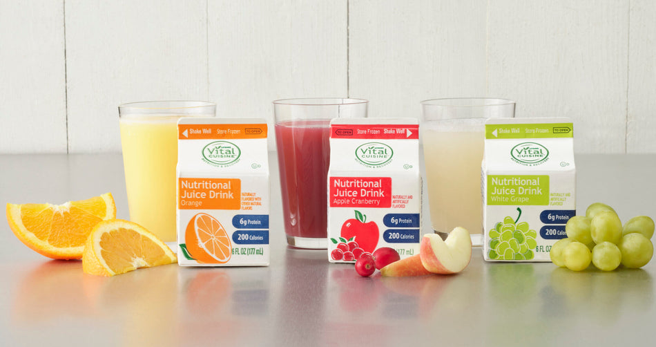 VitaPak nutritional juice drinks with fruit slices on a white surface.