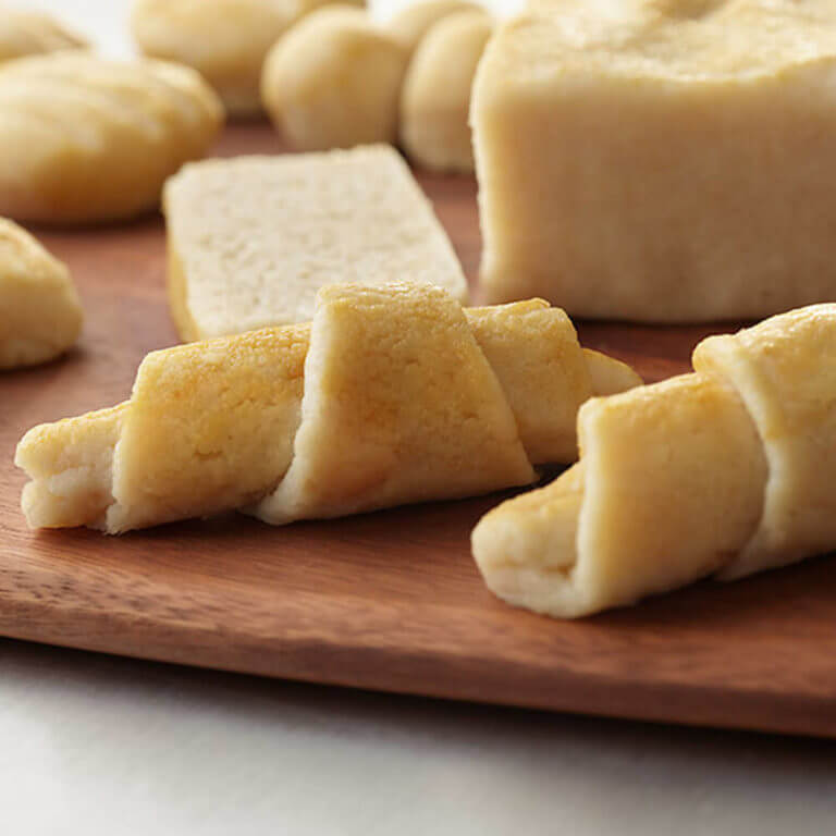 Rolled dough on a wooden board with a blurred background.