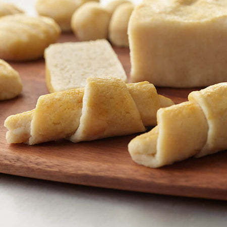 Rolled dough on a wooden board with a blurred background.