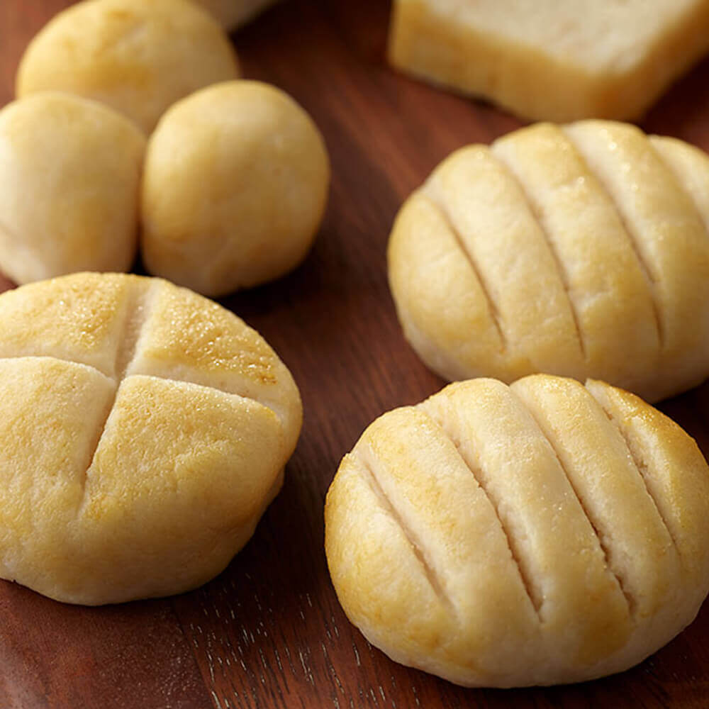 Close-up of bread rolls on a wooden surface.