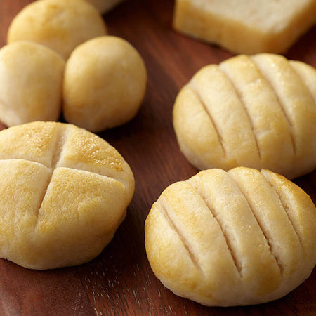 Close-up of bread rolls on a wooden surface.
