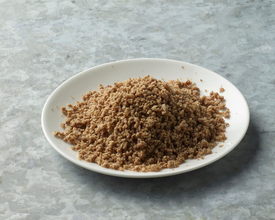 Brown sugar on a white plate with a gray background.