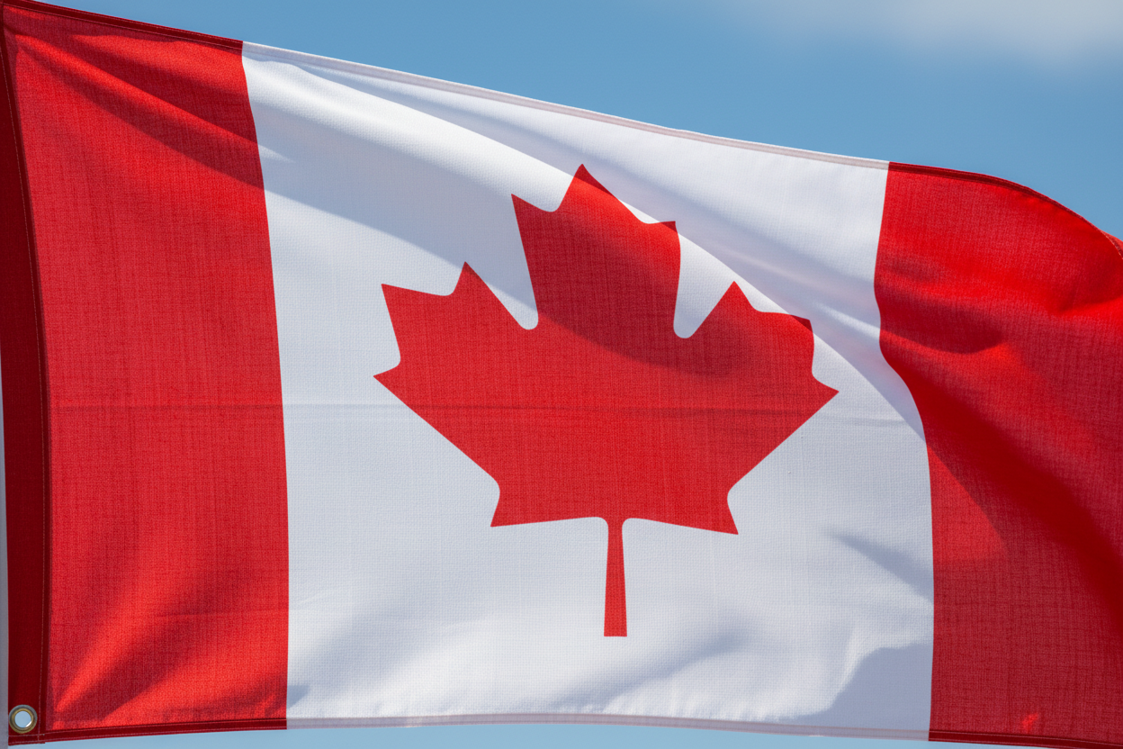 Canadian flag waving against a clear blue sky