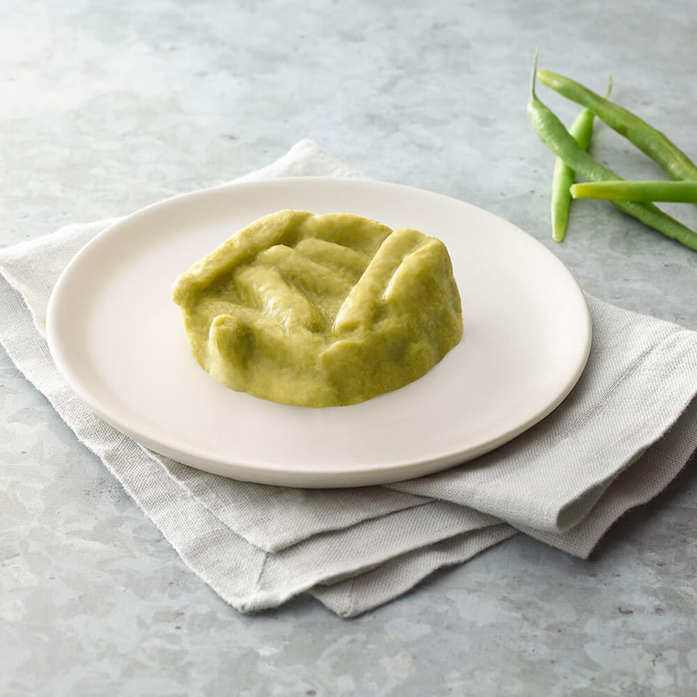 Green beans on a white plate with green beans on a gray surface.