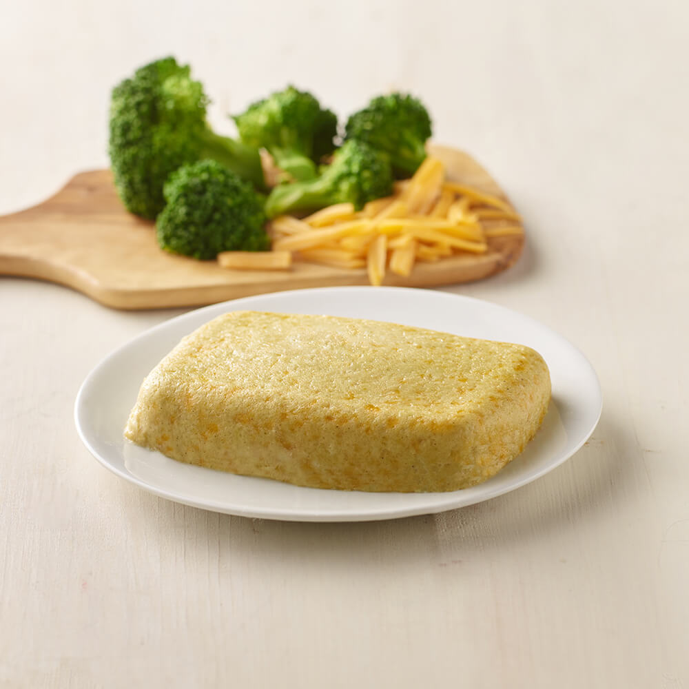 Rolled omelette on a plate with broccoli and cheese in the background.