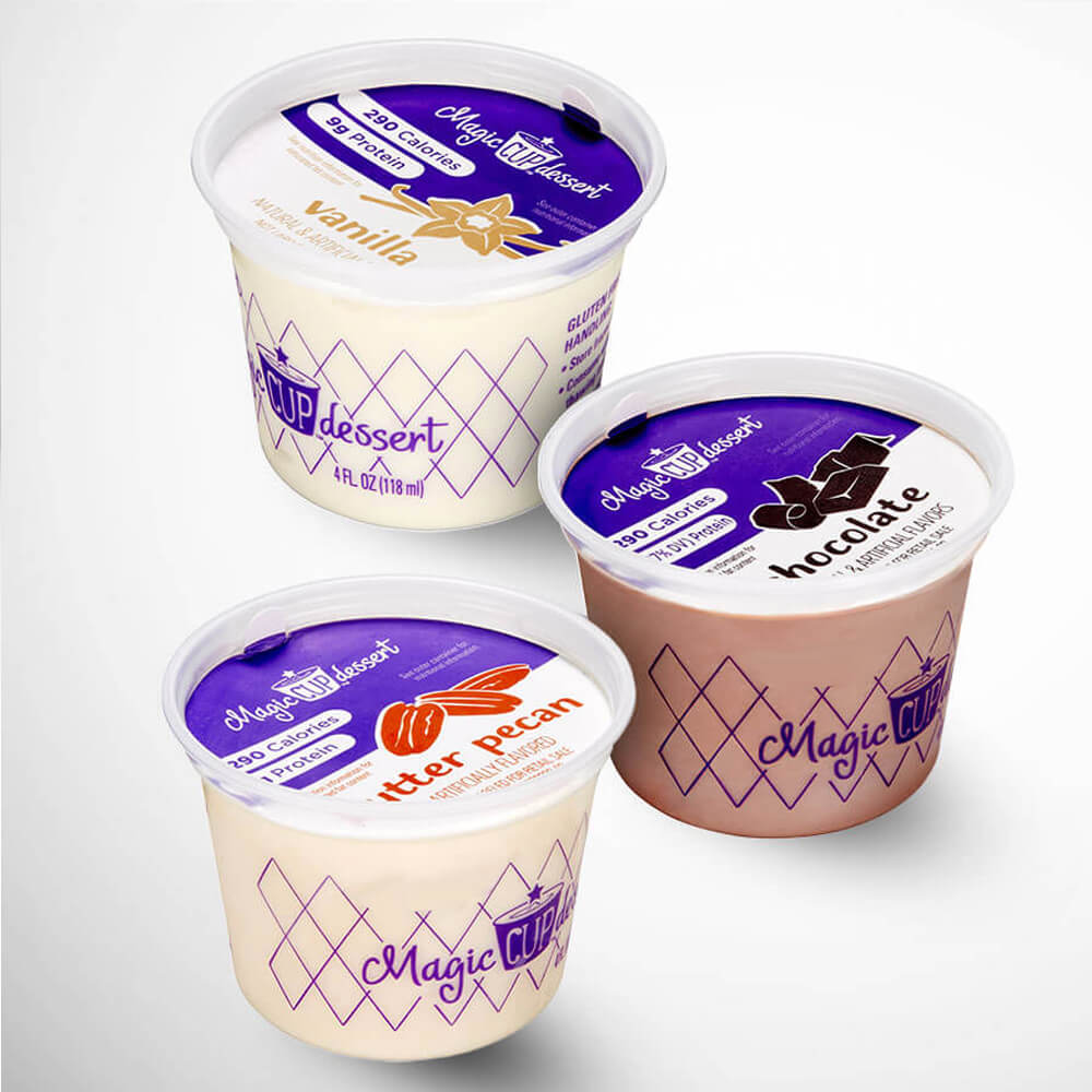 Four containers of Magic Bullet dessert in vanilla, chocolate, and other flavors on a white background.